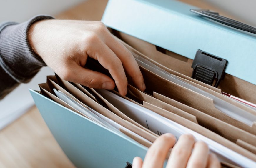 a person skimming through a record-keeping folder